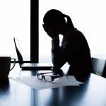 donna stressata davanti alla scrivania